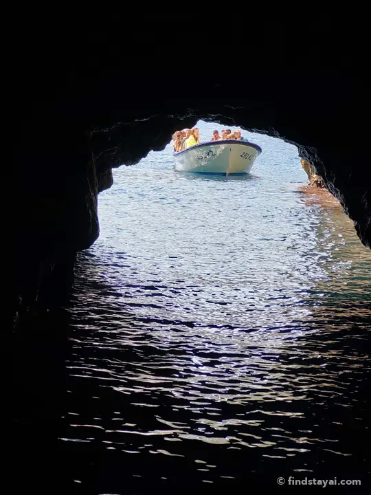Una barca incorniciata dall'arco di una grotta marina.